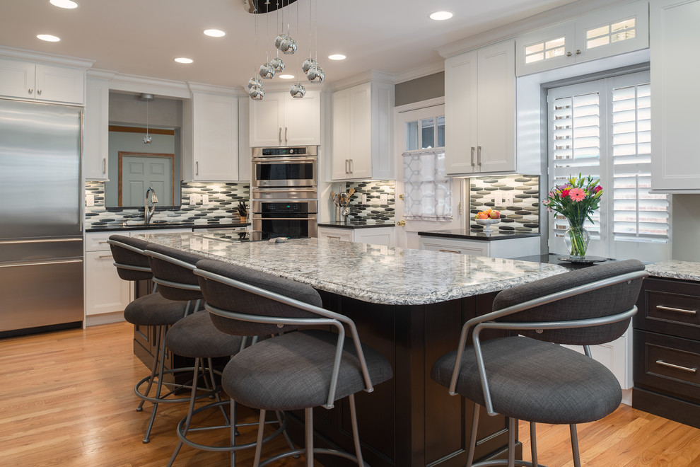 Transitional l-shaped light wood floor eat-in kitchen photo in St Louis with an undermount sink, shaker cabinets, white cabinets, quartz countertops, metallic backsplash, glass tile backsplash, stainless steel appliances and an island