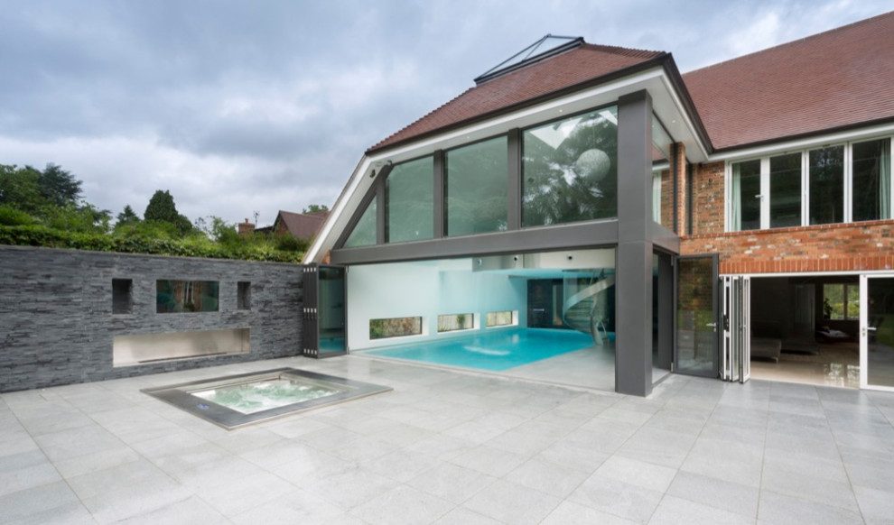 Design ideas for a medium sized and gey contemporary two floor detached house in Surrey with metal cladding, a hip roof, a tiled roof and a brown roof.