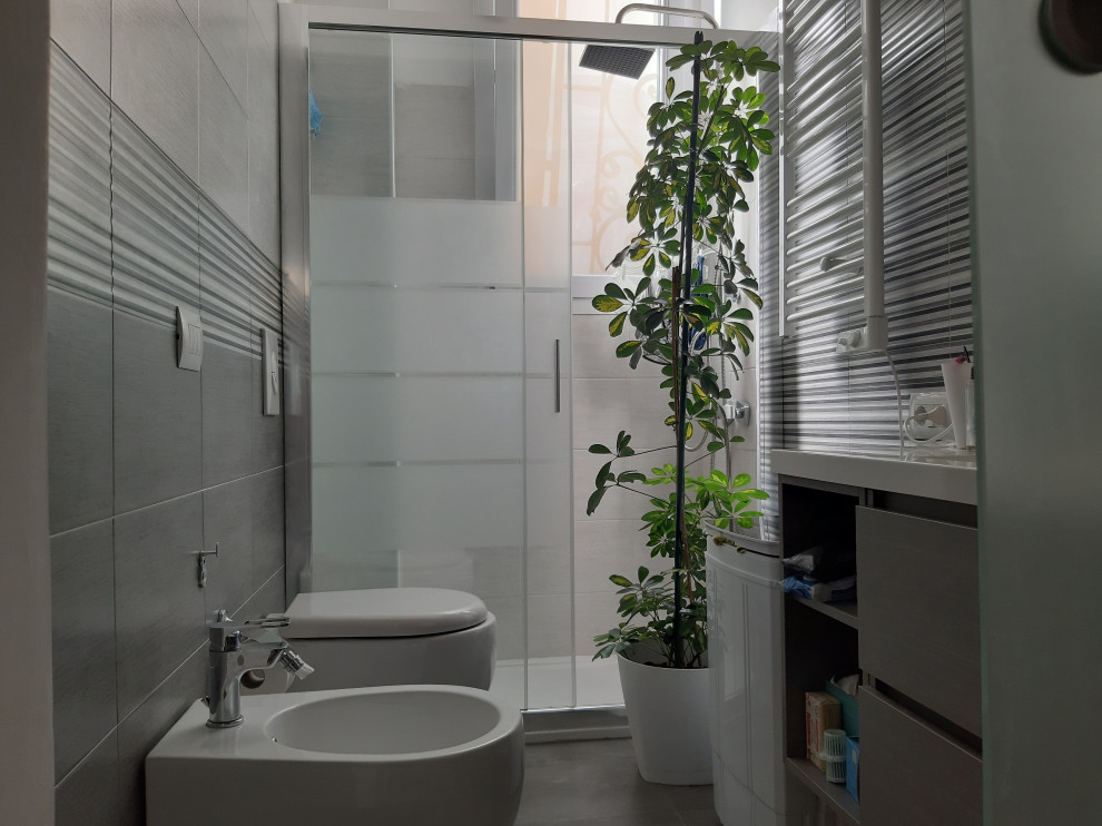 Ejemplo de cuarto de baño único y flotante moderno pequeño con armarios con paneles lisos, puertas de armario grises, paredes grises, suelo de baldosas de porcelana, aseo y ducha, suelo gris y encimeras blancas