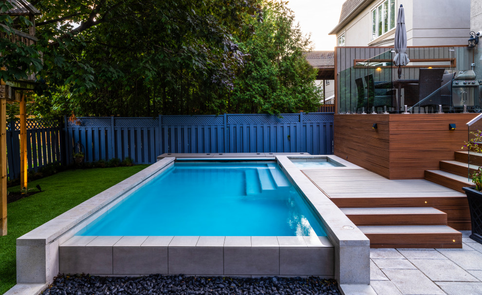 Small minimalist backyard concrete paver and rectangular infinity hot tub photo in Toronto