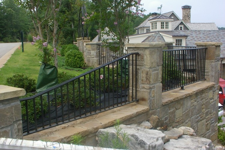 This is an example of a mid-sized traditional backyard partial sun outdoor sport court for summer in Atlanta with a retaining wall and natural stone pavers.