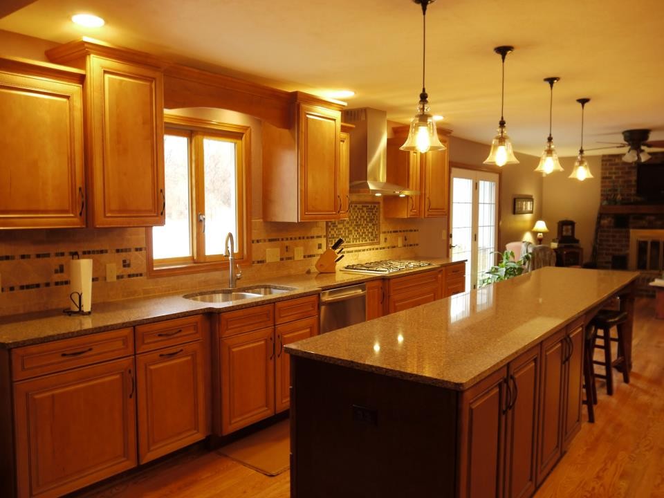 Kitchen - large transitional galley kitchen idea in Grand Rapids with an undermount sink, raised-panel cabinets, medium tone wood cabinets, granite countertops, multicolored backsplash, stainless steel appliances and an island