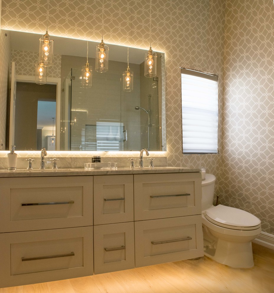 Inspiration for a mid-sized transitional master yellow tile and stone tile light wood floor and beige floor corner shower remodel with shaker cabinets, white cabinets, marble countertops, a one-piece toilet, gray walls and a hinged shower door