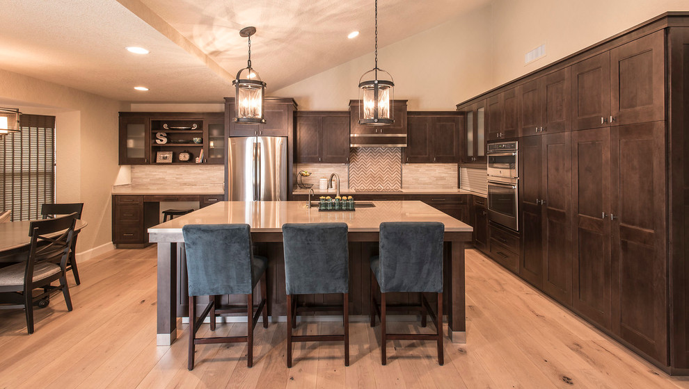 Eat-in kitchen - large transitional l-shaped light wood floor eat-in kitchen idea in Phoenix with an undermount sink, shaker cabinets, dark wood cabinets, quartz countertops, beige backsplash, matchstick tile backsplash, stainless steel appliances and an island