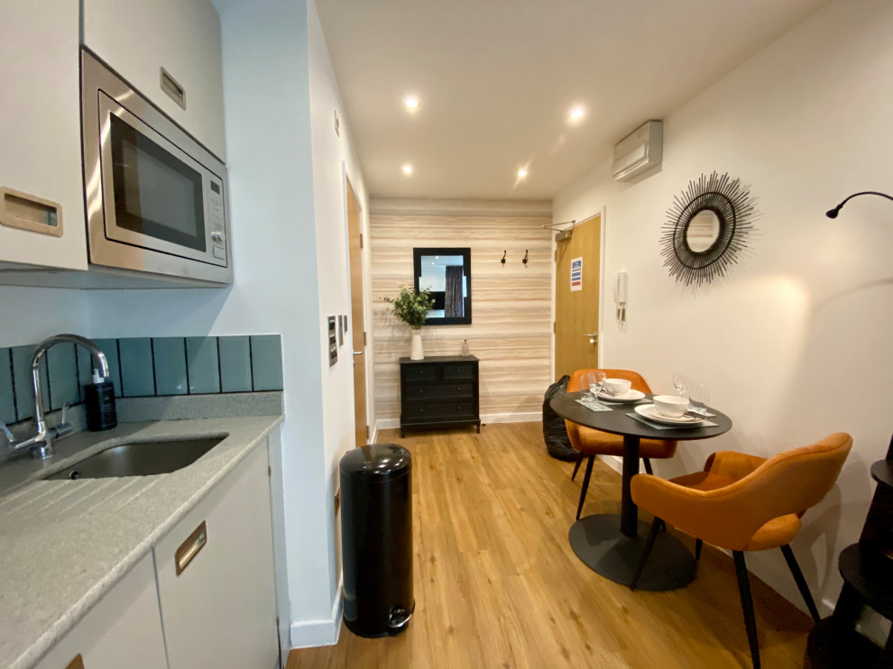 Свежая идея для дизайна: маленькая кухня в современном стиле с полом из ламината и оранжевым полом для на участке и в саду - отличное фото интерьера