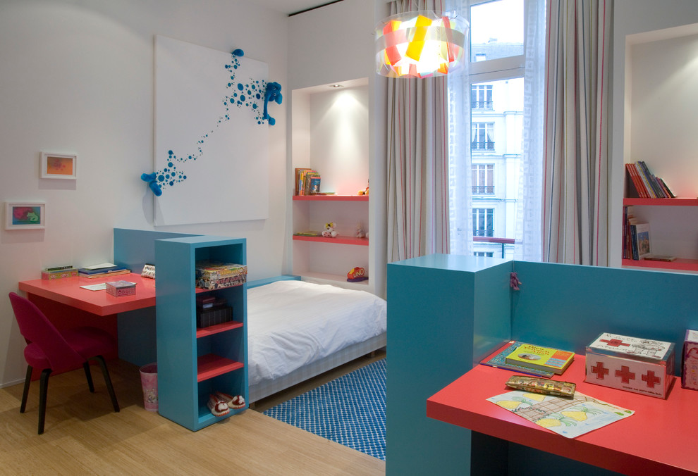 This is an example of a contemporary gender-neutral kids' bedroom for kids 4-10 years old in Paris with white walls and light hardwood floors.