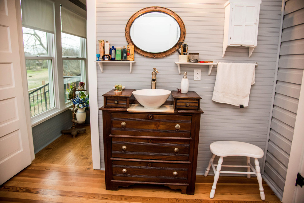 Mid-sized country 3/4 bathroom in Austin with flat-panel cabinets, dark wood cabinets, a two-piece toilet, grey walls, dark hardwood floors, a vessel sink, wood benchtops, brown floor, a claw-foot tub, a shower/bathtub combo and a shower curtain.