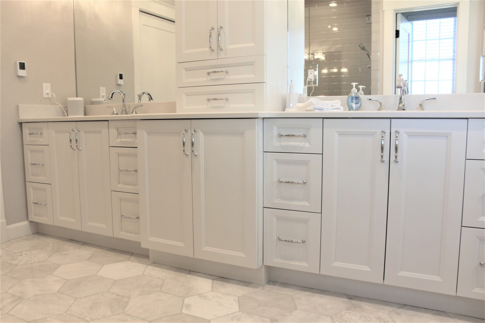 Inspiration for a large transitional master marble floor and double-sink wet room remodel in Detroit with recessed-panel cabinets, white cabinets, a two-piece toilet, an undermount sink, quartz countertops, a hinged shower door, white countertops and a freestanding vanity