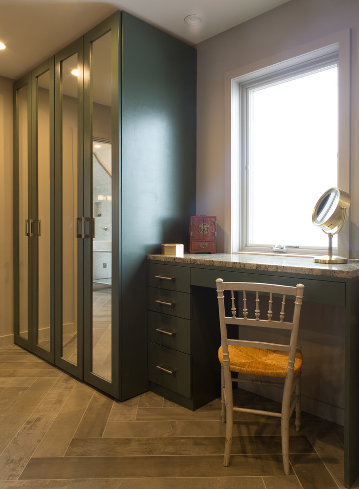 Large modern gender-neutral dressing room in New York with shaker cabinets, green cabinets, medium hardwood floors and brown floor.