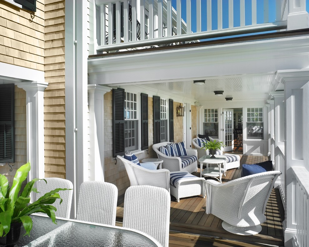 Design ideas for a mid-sized beach style backyard deck in Boston with a roof extension.