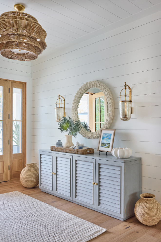 2 Chicks Happy Family Home - Coastal Entry Foyer with Blue Console and Rattan Pendant. A welcoming custom home entry by 2 Chicks Design Co featuring a blue louvered console, a beaded textured round mirror, wall sconces, a woven rattan pendant, and shiplap. A layered coastal transitional foyer designed for a Ponte Vedra Beach family home.
Tags: Beach Style, Transitional, Foyer, Entryway, Shiplap, Rattan Pendant, Blue Console, Capiz Mirror