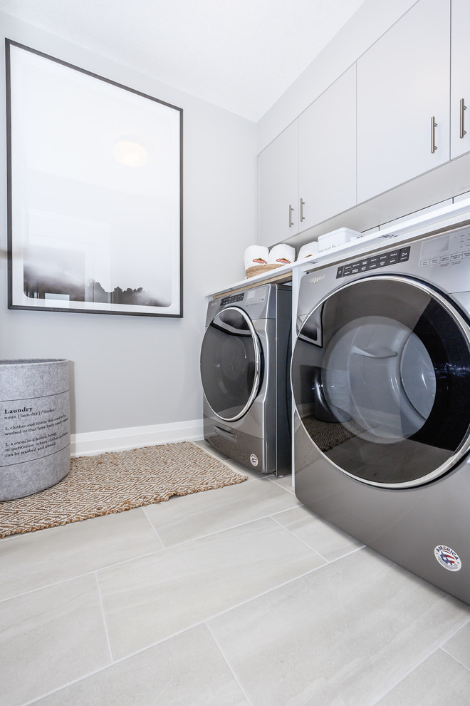 Design ideas for a large contemporary laundry room in Toronto with flat-panel cabinets, grey walls, porcelain floors and grey floor.