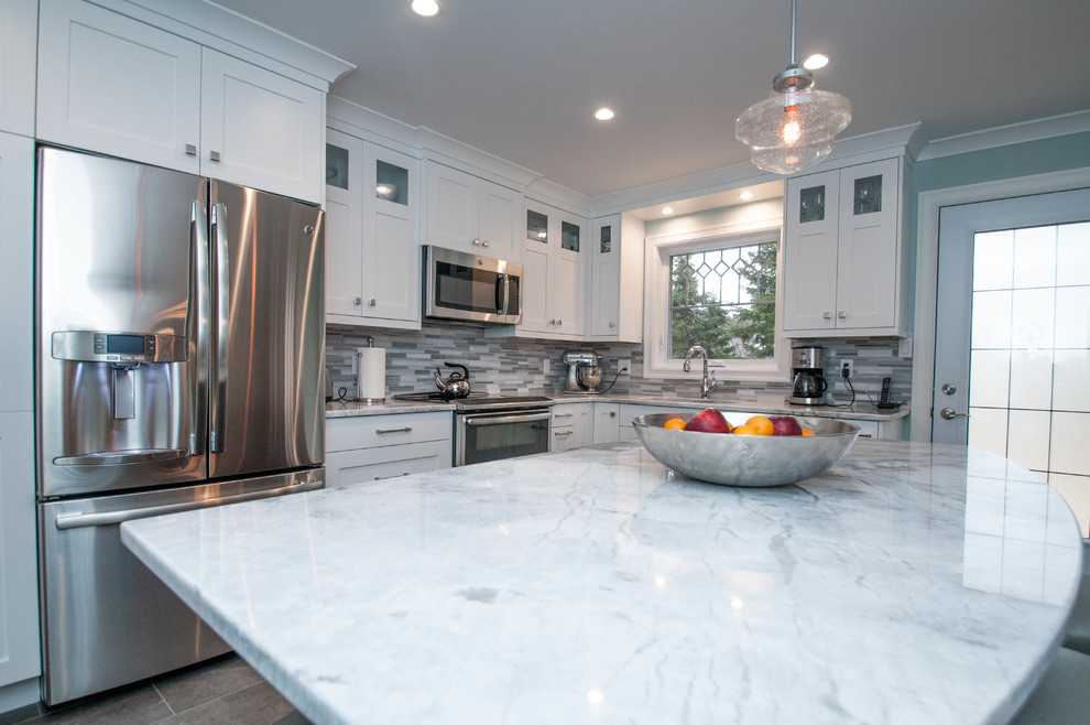 Eat-in kitchen - mid-sized transitional l-shaped ceramic tile eat-in kitchen idea with an undermount sink, shaker cabinets, white cabinets, quartzite countertops, gray backsplash, stone tile backsplash, stainless steel appliances and an island