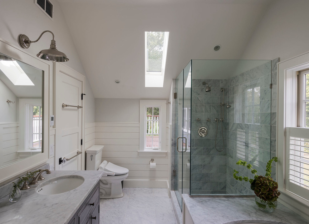 Inspiration for a country master bathroom in New York with an undermount sink, raised-panel cabinets, a corner shower, a two-piece toilet and grey walls.