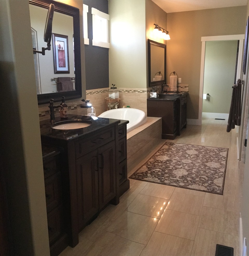Large elegant l-shaped and master drop-in bathtub photo in Edmonton with an undermount sink, recessed-panel cabinets, granite countertops, stainless steel appliances, an island, dark wood cabinets and green walls