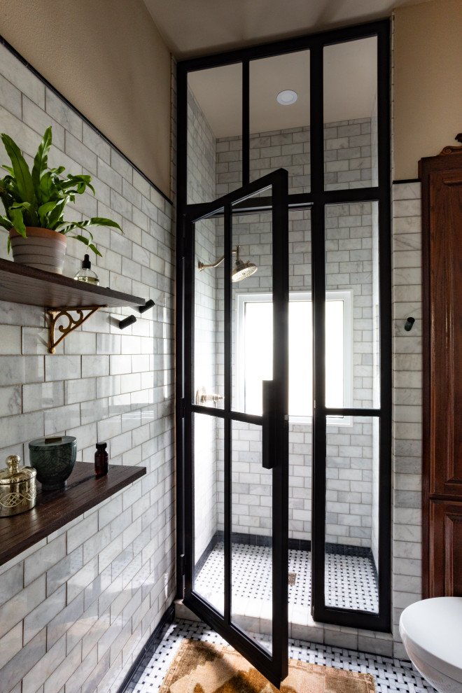 This is an example of a small transitional master bathroom in Austin with brown cabinets, an alcove shower, a two-piece toilet, gray tile, ceramic tile, beige walls, ceramic floors, a drop-in sink, grey floor, a hinged shower door, black benchtops, a niche, a single vanity and a freestanding vanity.