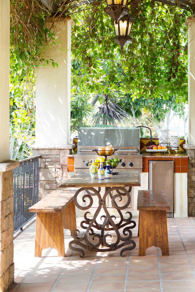 Inspiration for a mediterranean side yard verandah in Los Angeles with an outdoor kitchen, a pergola and tile.