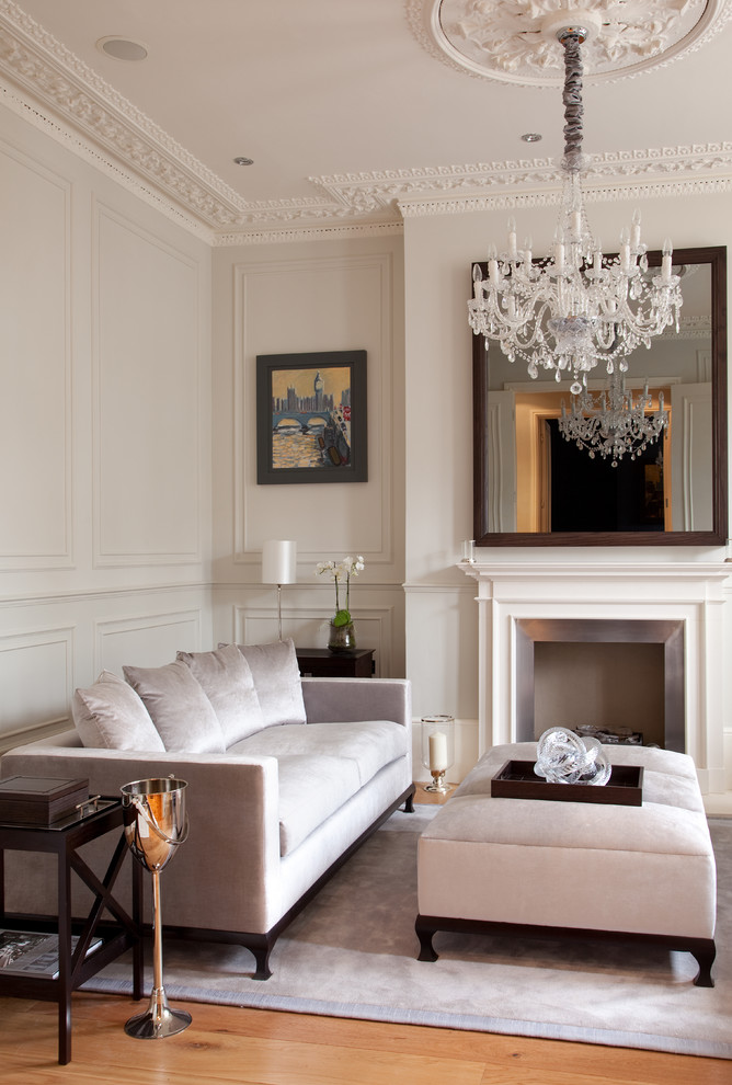 Photo of a traditional formal living room in London with grey walls, medium hardwood floors and a standard fireplace.