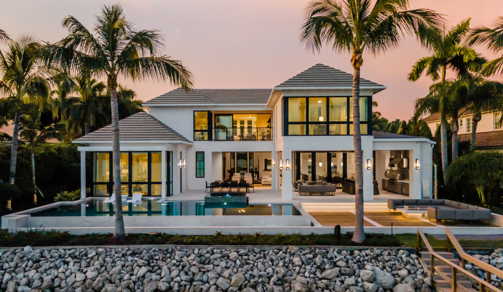 Contemporary two-storey white house exterior in Miami with a hip roof, a shingle roof and a grey roof.