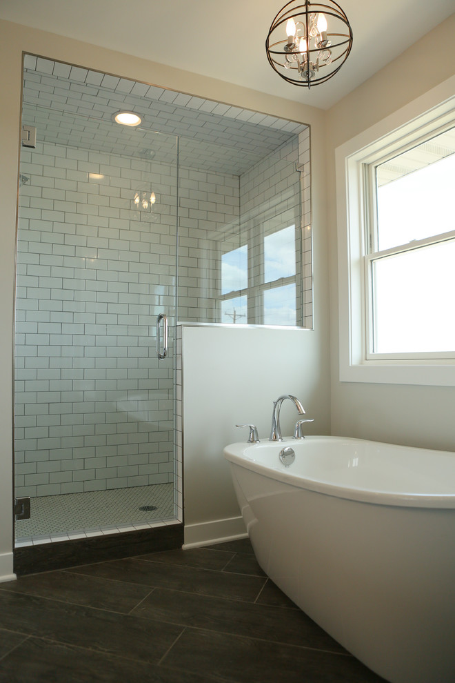 This is an example of a mid-sized transitional master bathroom in Chicago with shaker cabinets, white cabinets, a freestanding tub, a corner shower, a two-piece toilet, porcelain tile, grey walls, porcelain floors, a drop-in sink and engineered quartz benchtops.