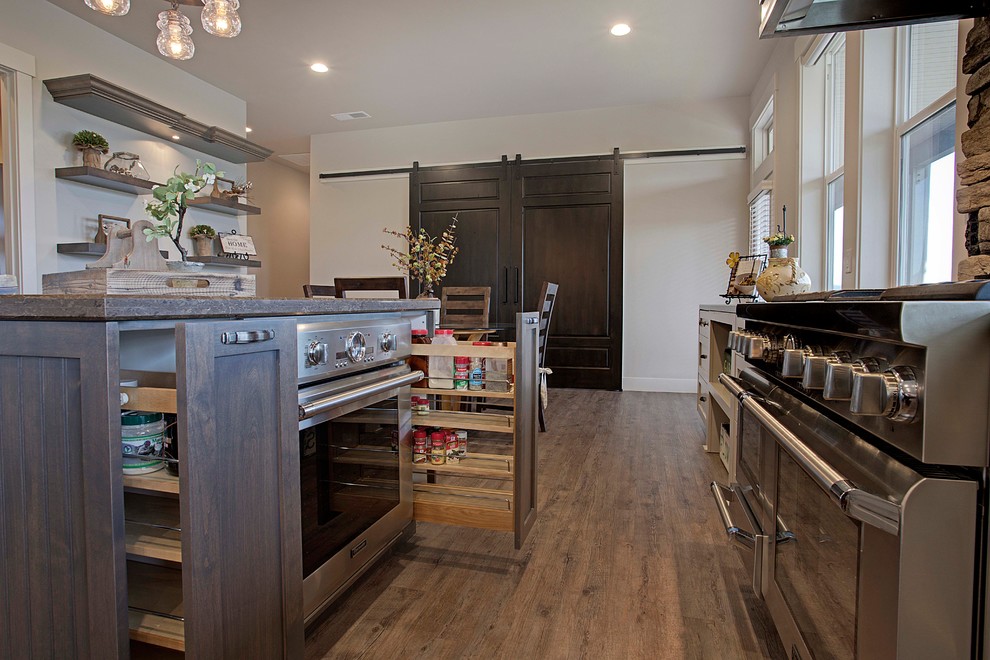 Design ideas for a large transitional kitchen in Sacramento with a farmhouse sink, shaker cabinets, grey cabinets, granite benchtops, multi-coloured splashback, stainless steel appliances, vinyl floors and multiple islands.