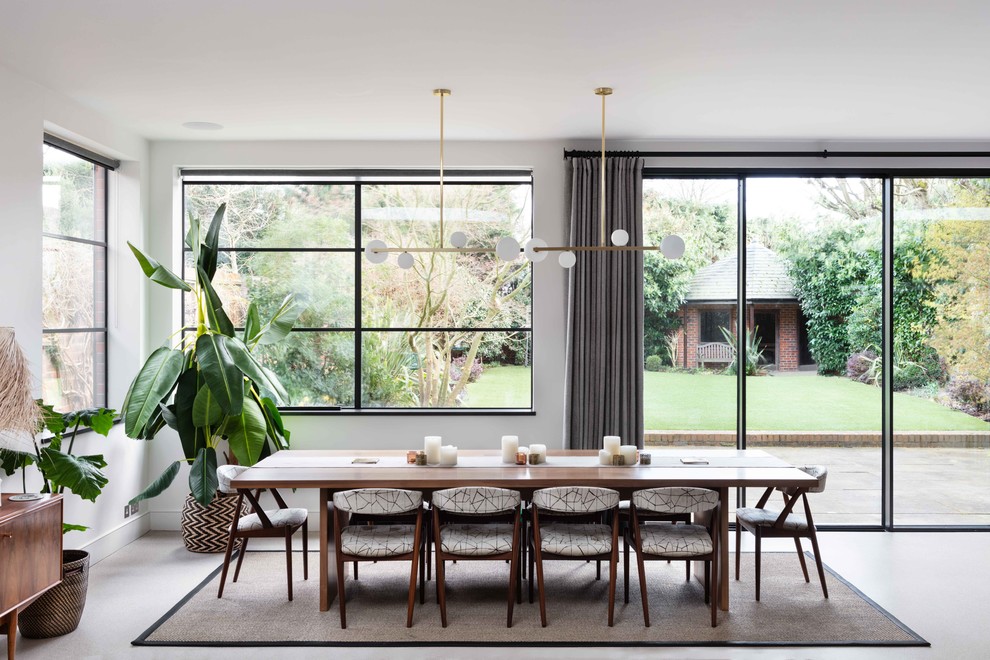Photo of a large contemporary dining room in London with white walls, concrete floors and grey floor.