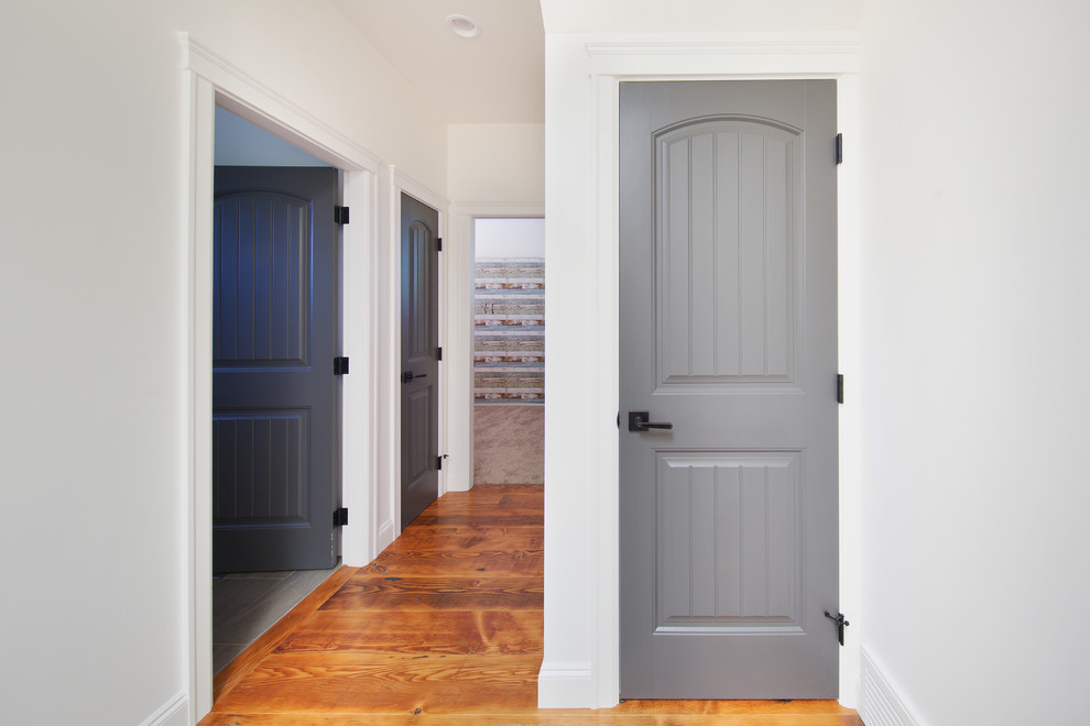 Example of a mid-sized mountain style medium tone wood floor hallway design in Vancouver with white walls