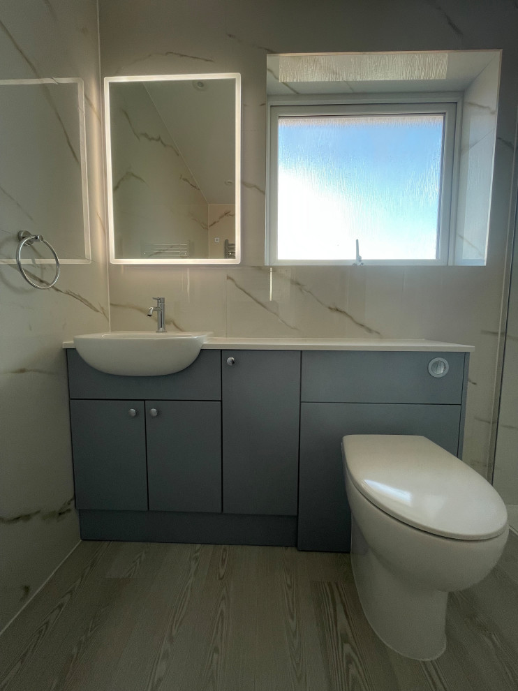 Design ideas for a mid-sized modern 3/4 bathroom in Hampshire with flat-panel cabinets, blue cabinets, an open shower, a one-piece toilet, white tile, vinyl floors, an integrated sink, quartzite benchtops, an open shower, white benchtops, a single vanity and a built-in vanity.