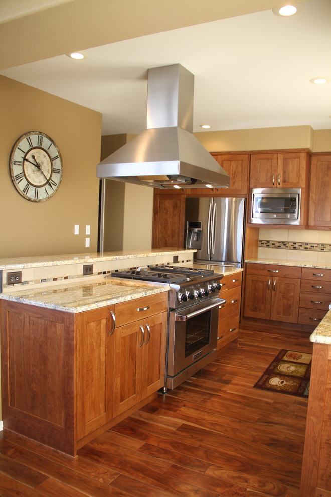 Example of a large transitional u-shaped medium tone wood floor eat-in kitchen design in Seattle with an undermount sink, shaker cabinets, medium tone wood cabinets, granite countertops, beige backsplash, porcelain backsplash, stainless steel appliances and an island