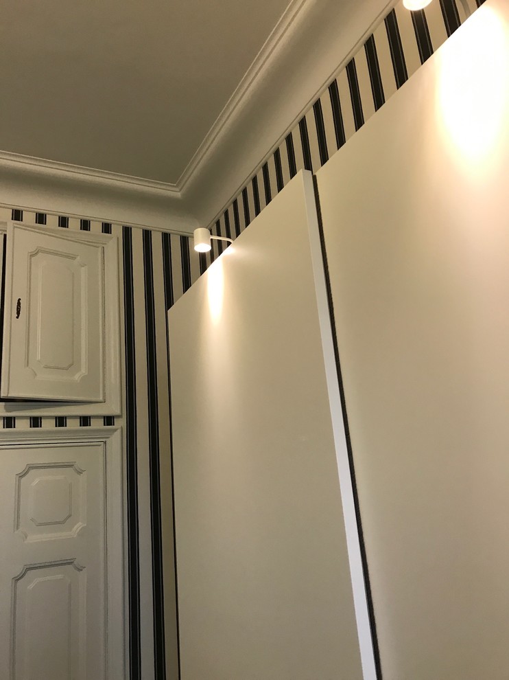 This is an example of a modern gender-neutral dressing room in Other with flat-panel cabinets, white cabinets, linoleum floors and black floor.