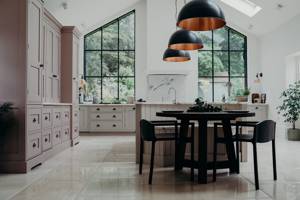 Photo of a large country u-shaped eat-in kitchen in Surrey with a drop-in sink, beaded inset cabinets, pink cabinets, marble benchtops, white splashback, marble splashback, stainless steel appliances, limestone floors, with island, beige floor, white benchtop and vaulted.