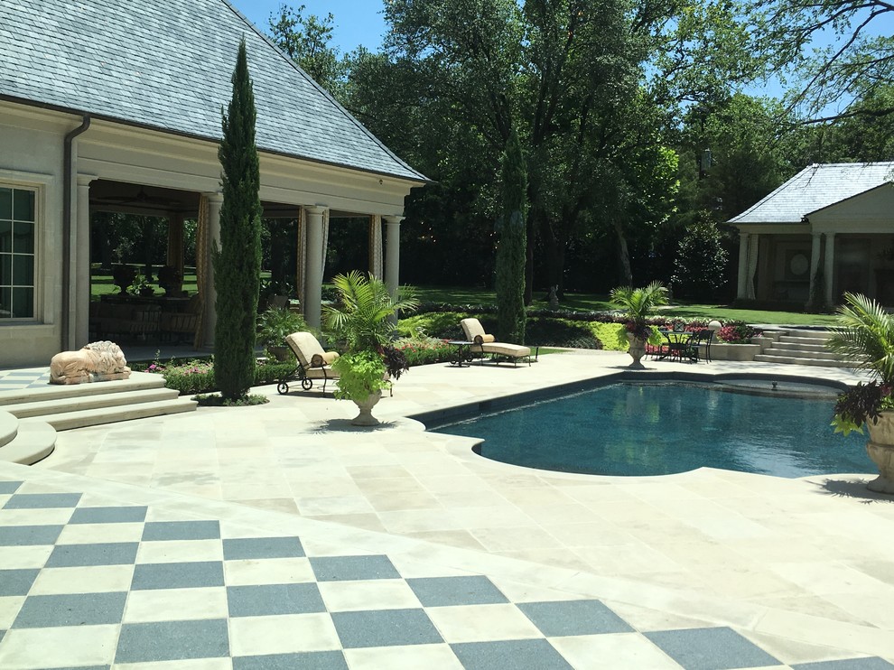Design ideas for a large traditional backyard custom-shaped natural pool in Dallas with a pool house and natural stone pavers.