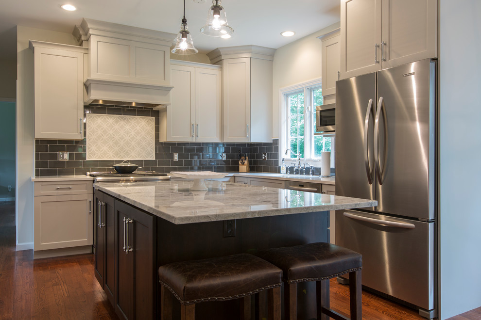 This is an example of a mid-sized transitional l-shaped eat-in kitchen in Bridgeport with an undermount sink, recessed-panel cabinets, grey cabinets, granite benchtops, black splashback, ceramic splashback, stainless steel appliances, medium hardwood floors and with island.