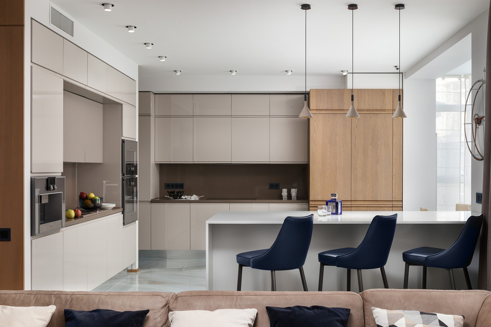 Photo of a contemporary open plan kitchen in Other with flat-panel cabinets, brown splashback, a peninsula, beige cabinets, white floor and brown benchtop.