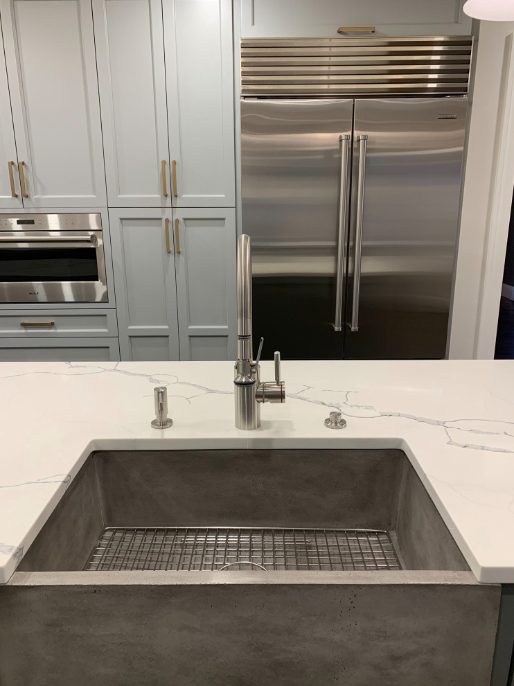 Inspiration for a large transitional galley dark wood floor and brown floor enclosed kitchen remodel in Boston with a farmhouse sink, raised-panel cabinets, gray cabinets, quartzite countertops, white backsplash, stone slab backsplash, stainless steel appliances, an island and white countertops