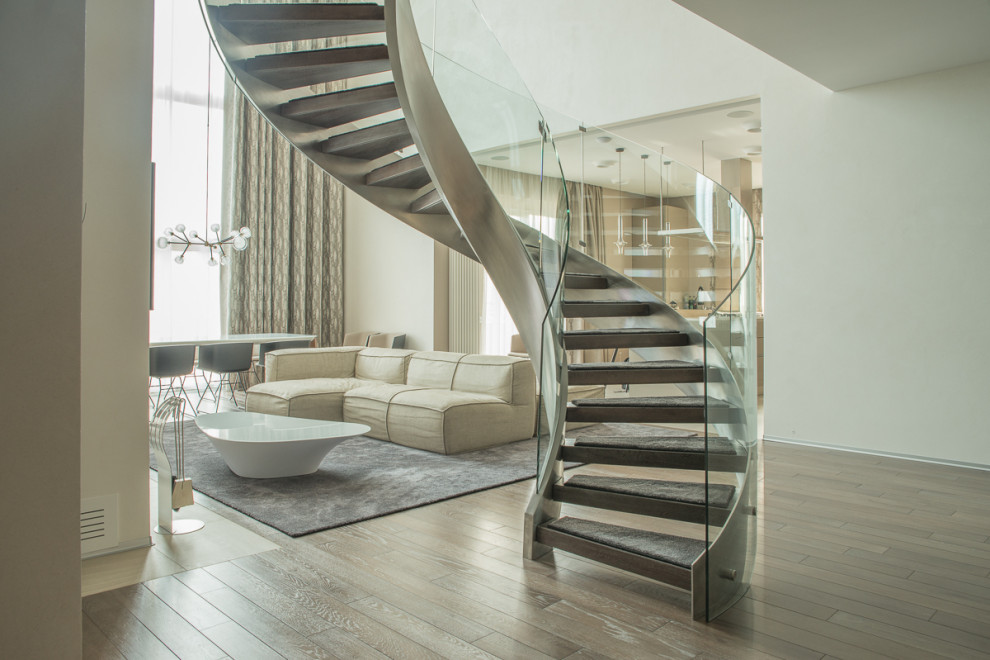 Винтовая лестница Mercury forge со стеклянным ограждением.