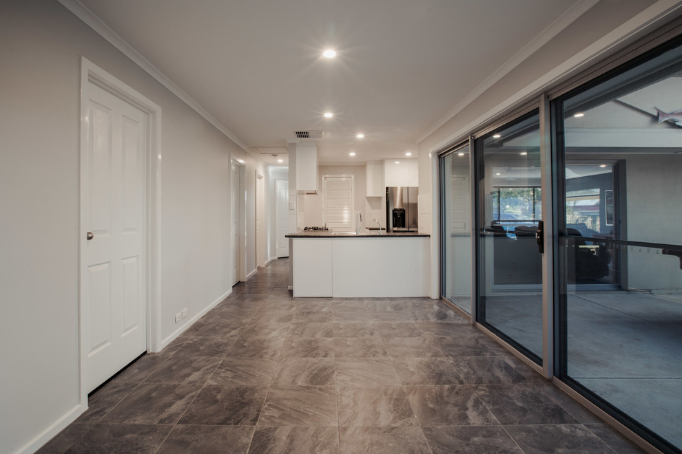 This is an example of a mid-sized contemporary kitchen/dining combo in Adelaide with white walls, ceramic floors, no fireplace and grey floor.