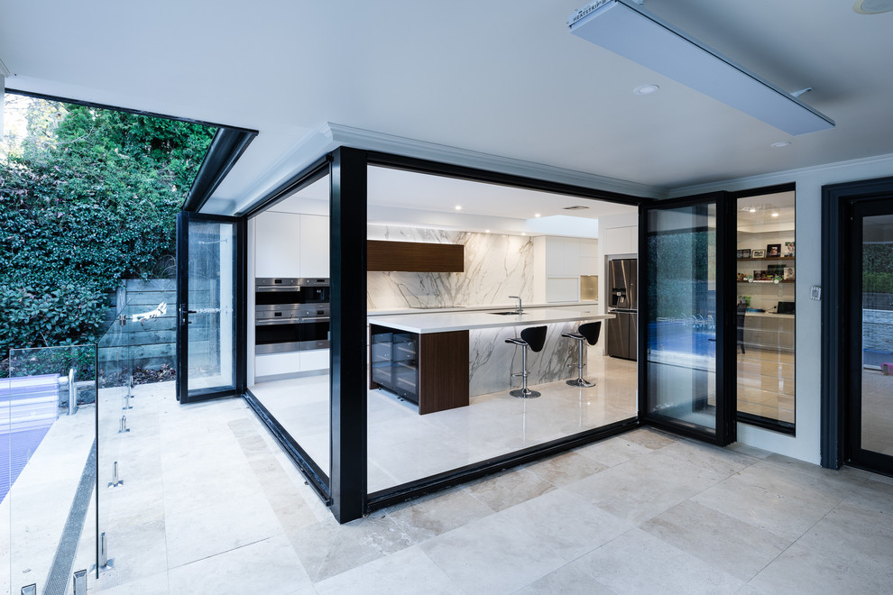 Expansive contemporary single-wall kitchen in Sydney with an undermount sink, flat-panel cabinets, white cabinets, marble benchtops, glass sheet splashback, stainless steel appliances, porcelain floors, with island, multi-coloured floor and multi-coloured benchtop.