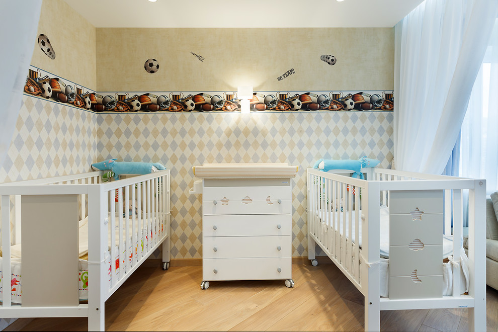 Inspiration for a mid-sized scandinavian nursery for boys in Saint Petersburg with multi-coloured walls, light hardwood floors and beige floor.