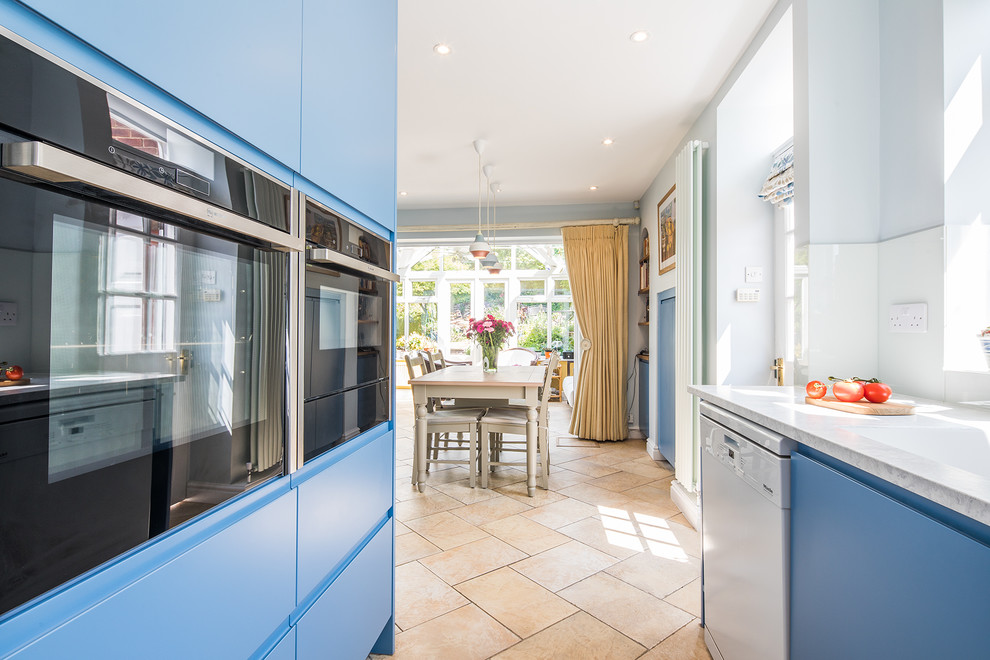 Mid-sized contemporary u-shaped eat-in kitchen in Other with an integrated sink, flat-panel cabinets, blue cabinets, laminate benchtops, blue splashback, glass sheet splashback, panelled appliances, ceramic floors, no island, beige floor and white benchtop.
