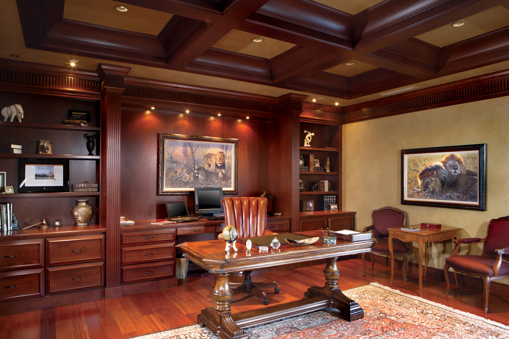 This is an example of an expansive mediterranean study in Phoenix with beige walls, medium hardwood flooring, a built-in desk, brown floors and a coffered ceiling.