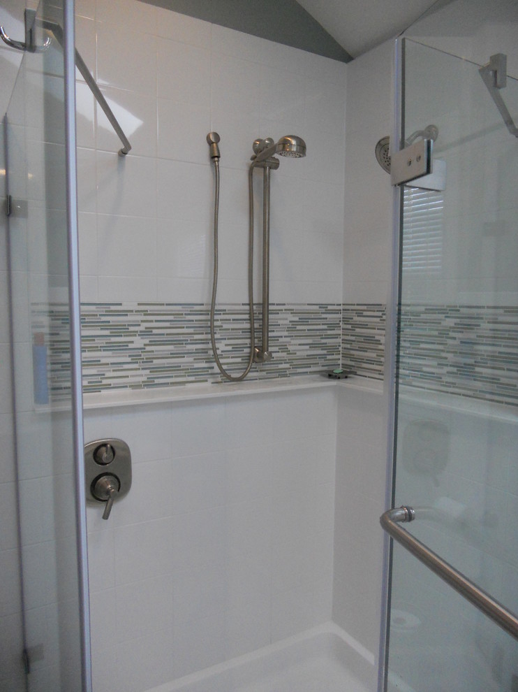 Inspiration for a large transitional master gray tile and stone tile ceramic tile corner bathtub remodel with an undermount sink, recessed-panel cabinets, dark wood cabinets, quartz countertops, a two-piece toilet and gray walls