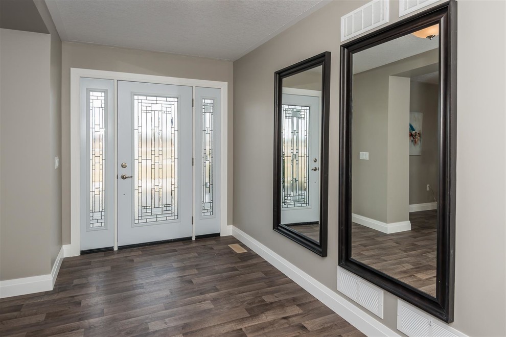 Example of a mid-sized transitional medium tone wood floor and brown floor foyer design with gray walls and a white front door