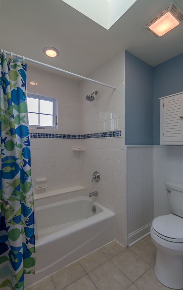 Small traditional 3/4 bathroom in Chicago with an alcove tub, a shower/bathtub combo, a one-piece toilet, blue walls, ceramic floors, white floor, a shower curtain, flat-panel cabinets, light wood cabinets, blue tile, ceramic tile, a drop-in sink, limestone benchtops, grey benchtops, a double vanity, a freestanding vanity, wallpaper and wallpaper.