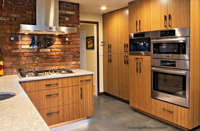Transitional kitchen in Seattle with medium wood cabinets, black splashback, porcelain floors and with island.