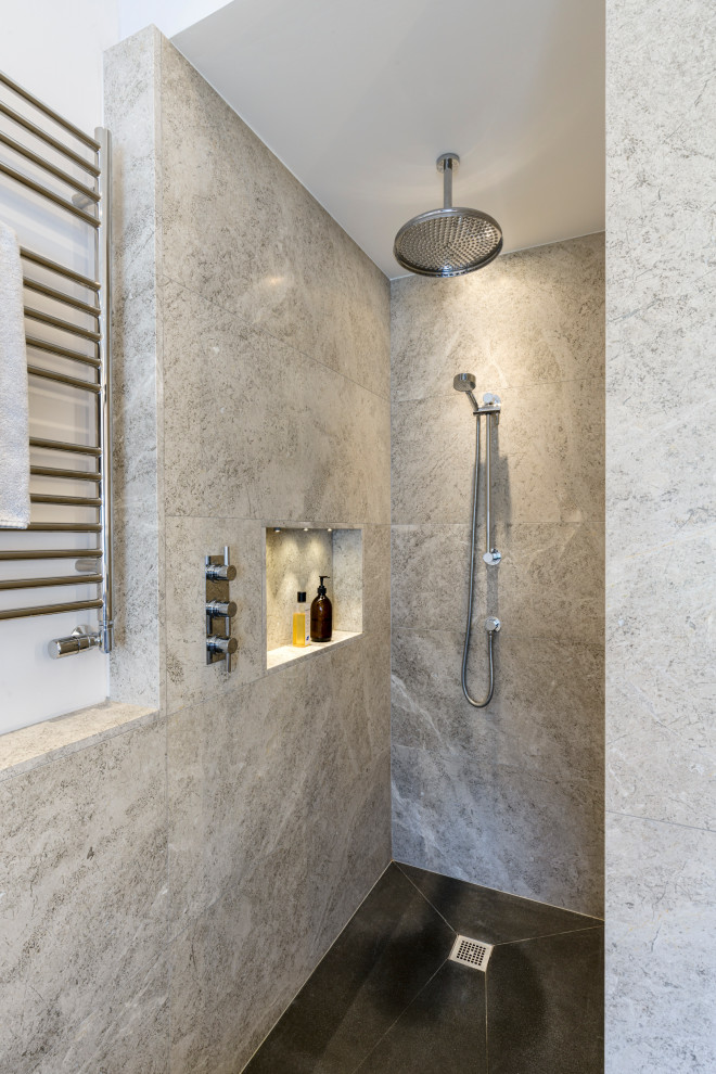 Cette image montre une salle de bain principale design avec une douche ouverte, du carrelage en pierre calcaire, un sol noir et aucune cabine.
