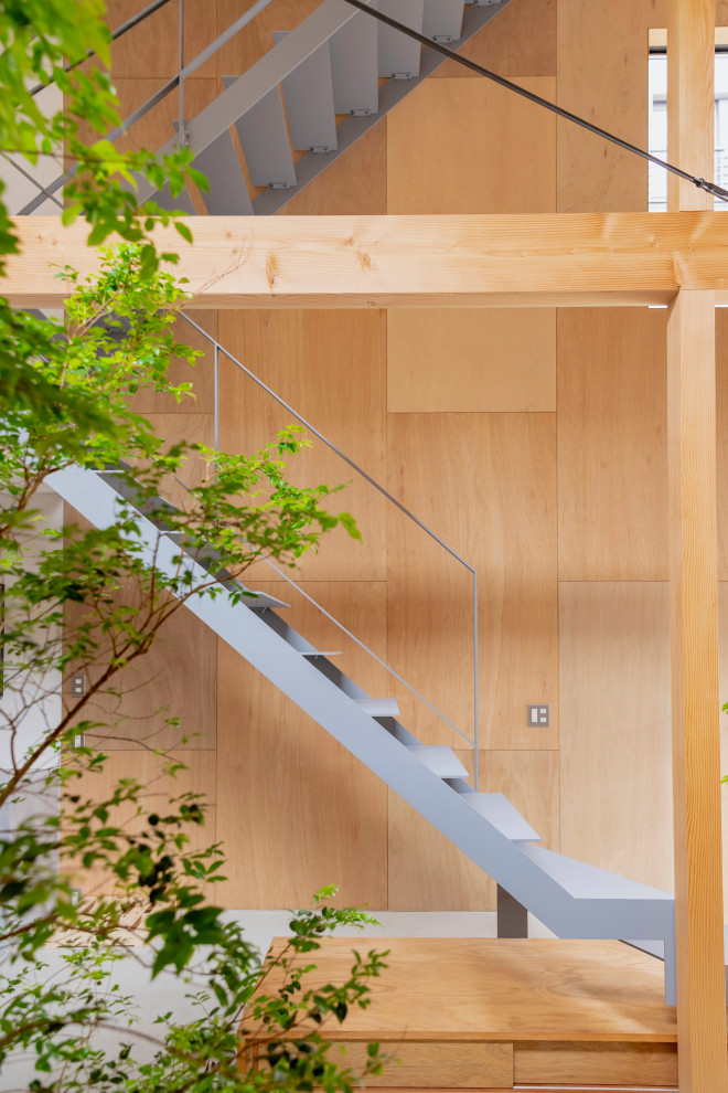 На фото: металлическая лестница на больцах, среднего размера в восточном стиле с металлическими ступенями, металлическими перилами и деревянными стенами с