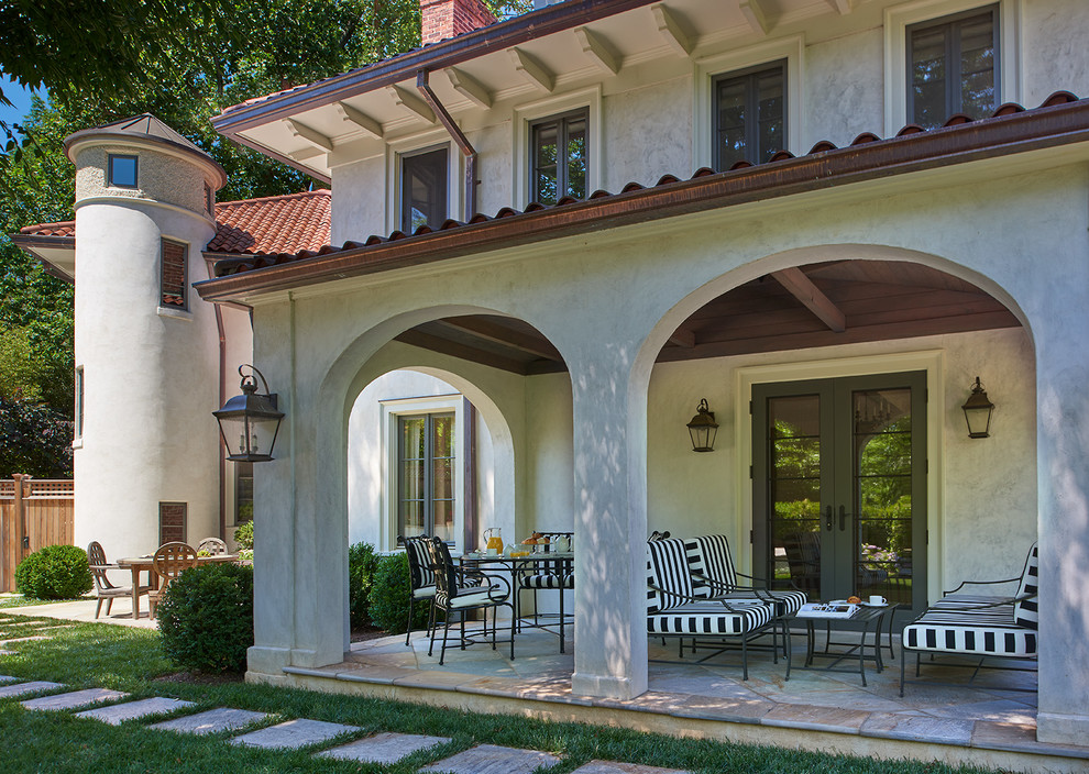 Photo of a large mediterranean side yard verandah in DC Metro with a roof extension and natural stone pavers.