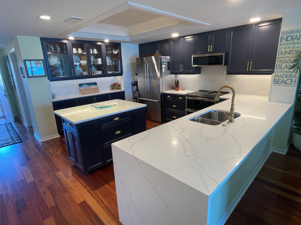 Inspiration for a mid-sized modern u-shaped eat-in kitchen in Tampa with blue cabinets, quartz benchtops, engineered quartz splashback and with island.
