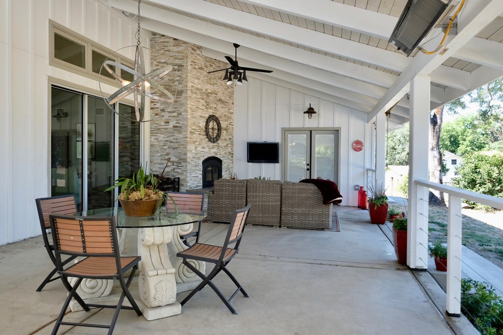 Design ideas for a large country backyard verandah in Sacramento with a fire feature, concrete slab and a roof extension.